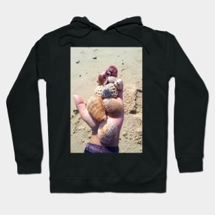 Seashells on a hand at the beach Hoodie